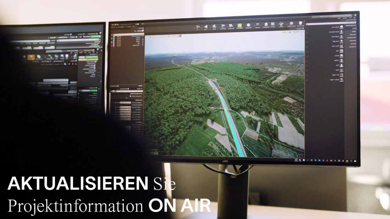 Person arbeitet an einer interaktiven Anwendung vor zwei Bildschirmen