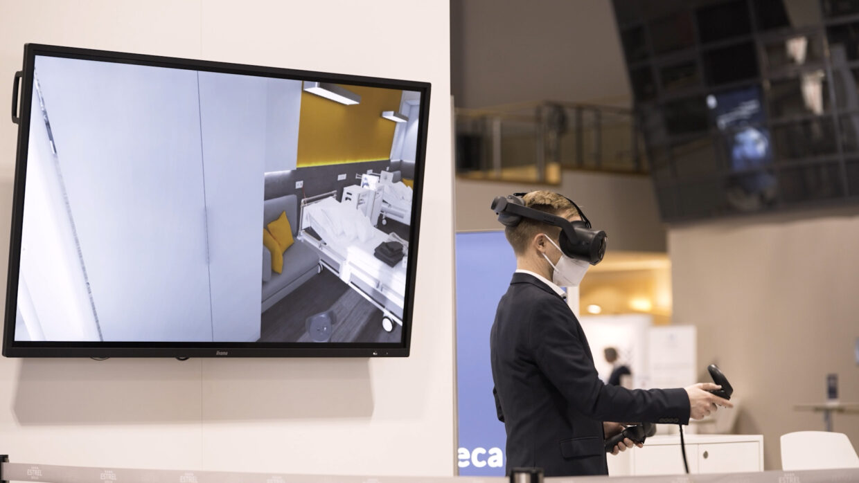 Man with VR glasses navigates through a computer generated hospital room.