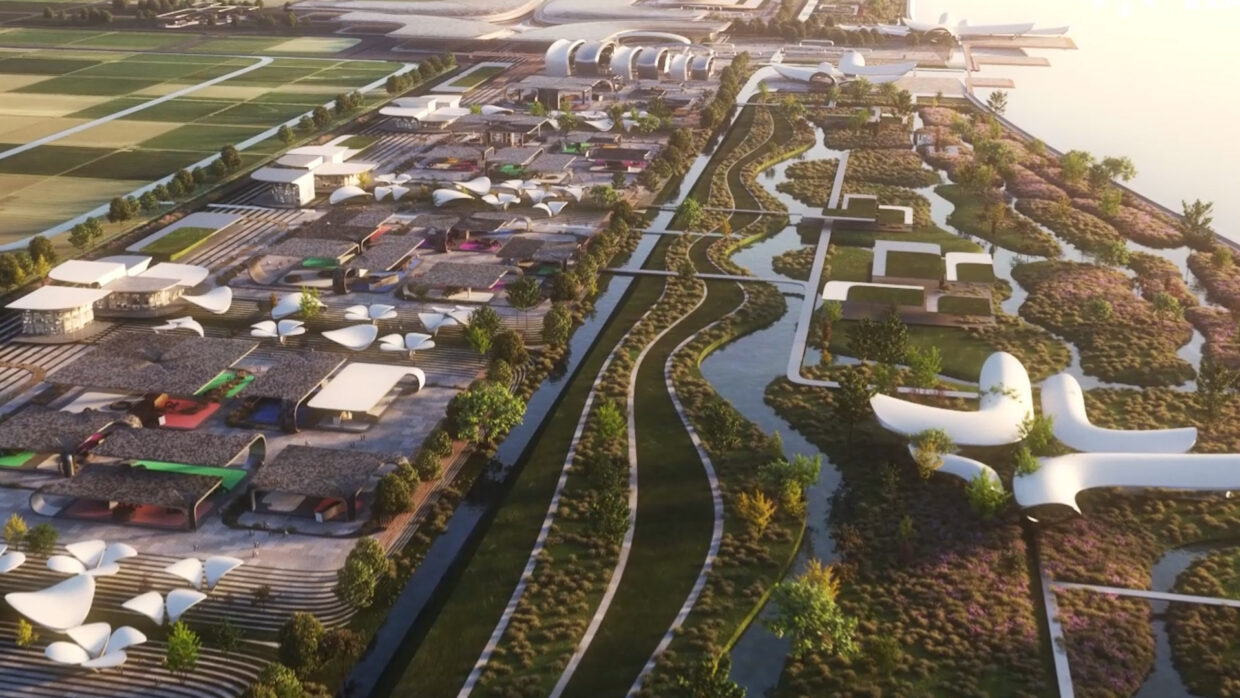 Drone shot of an open area on the coast with modern buildings, embedded in nature