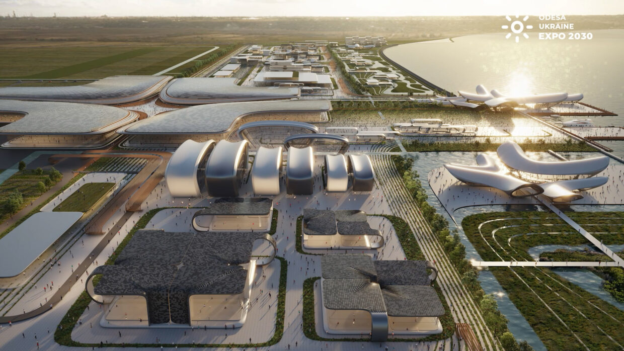 Drone shot of a big open area on the seaside at dawn, futuristic buildings.