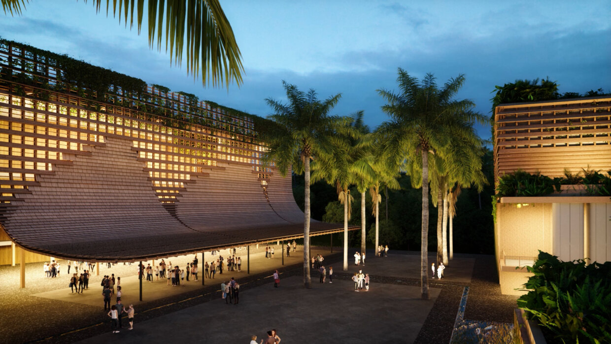 People standing in a modern, open timber building at night, surrounded by palmtrees.