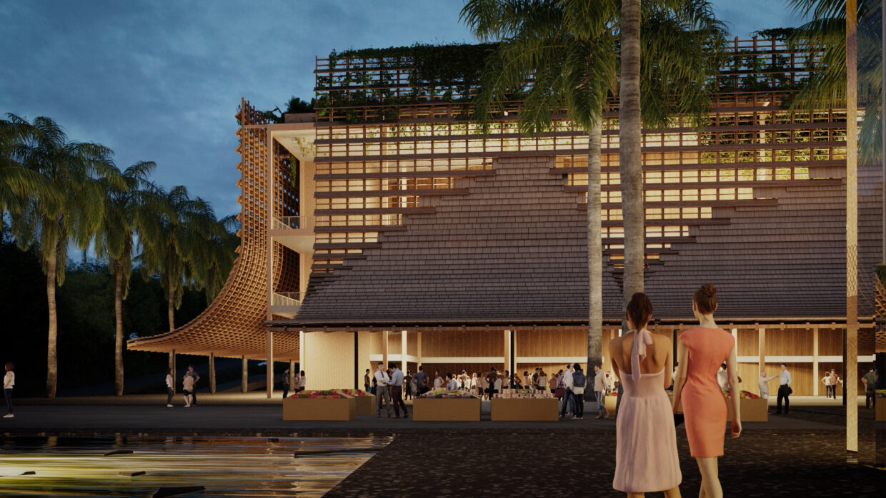 Two woman standing in front of a modern, open Tahitian building during nighttime.